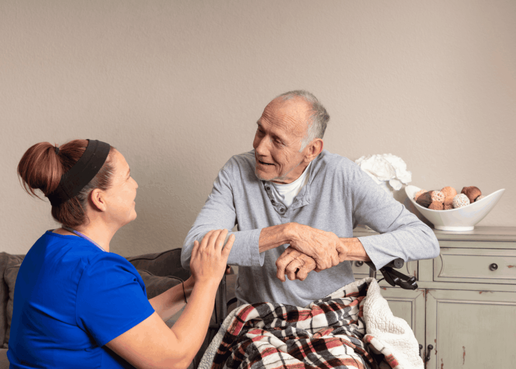 nurse talking to an elderly man in a wheelchair